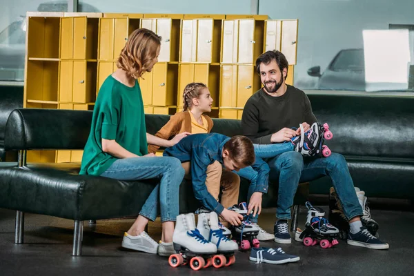 Семья носит роликовые коньки перед катанием в скейт-парке — стоковое фото