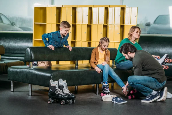 Família vestindo patins antes de patinar no parque de skate — Fotografia de Stock