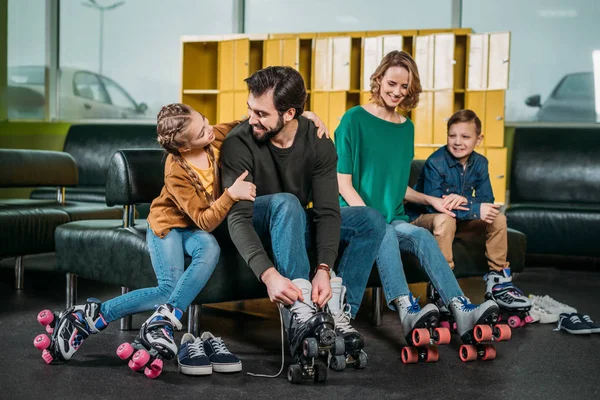 Familie ruht sich auf Sofa aus, bevor sie auf Rollschuhen im Skatepark Schlittschuh läuft — Stockfoto