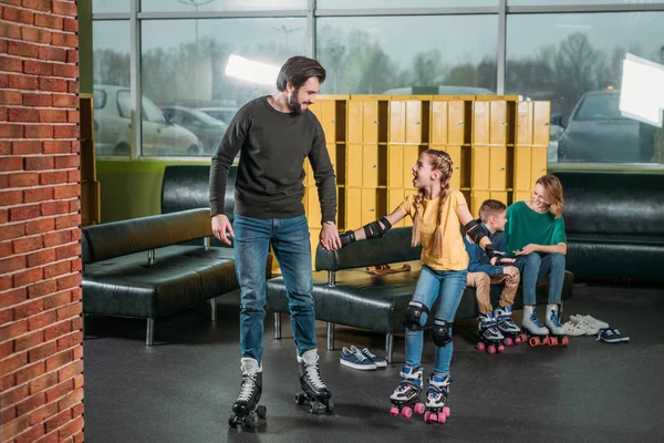 Father and daughter going on roller rink to skate in skate park — Stock Photo