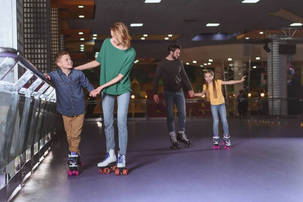 Parents and kids skating on roller rink together — Stock Photo