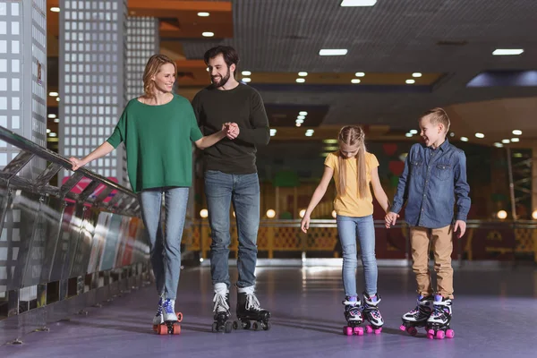 Parents and kids skating on roller rink together — Stock Photo