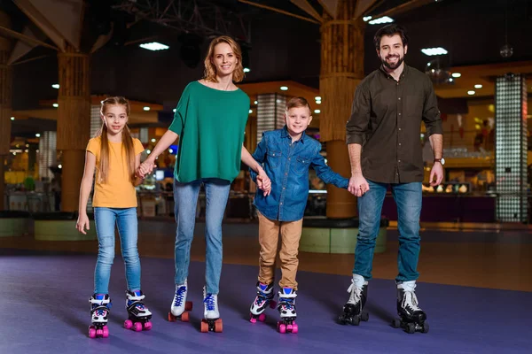 Parents and kids skating together on roller rink — Stock Photo