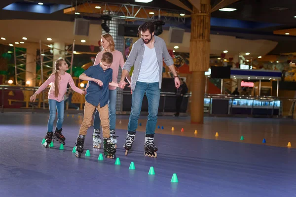 Family spending time together on roller rink with cones — Stock Photo