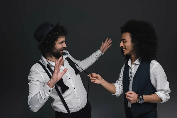 Jeunes hommes élégants s'amuser sur noir — Photo de stock