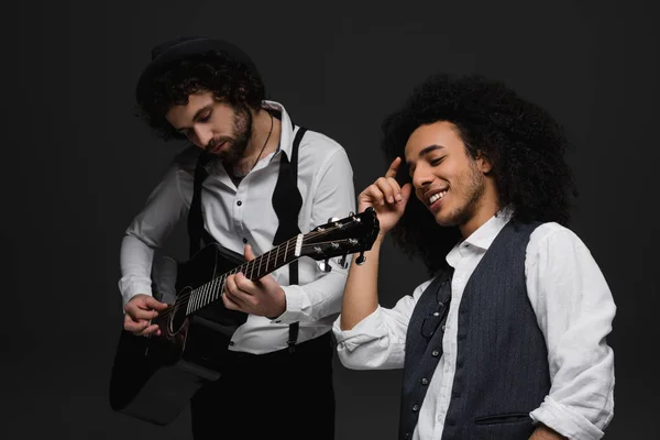 Dúo de músicos tocando la guitarra y cantando en negro - foto de stock