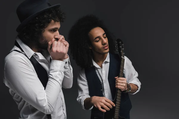 Duett von Musikern mit Akustikgitarre und Mundharmonika auf schwarz — Stockfoto