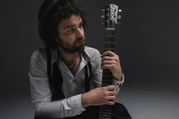 Joven músico reflexivo con guitarra acústica - foto de stock