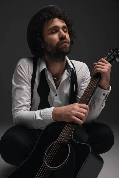 Young musician sitting on floor with acoustic guitar — Stock Photo