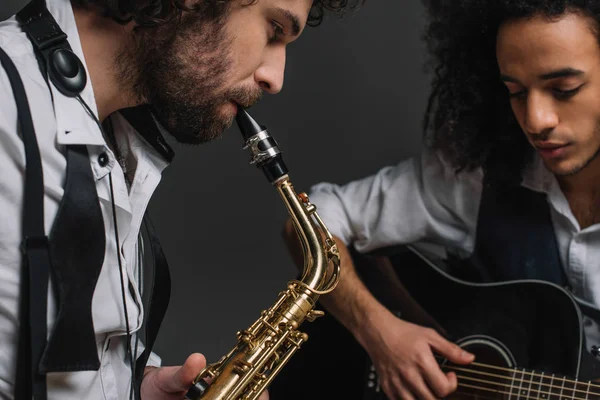 Duo de jazzmen jouant du saxophone et de la guitare acoustique sur noir — Photo de stock