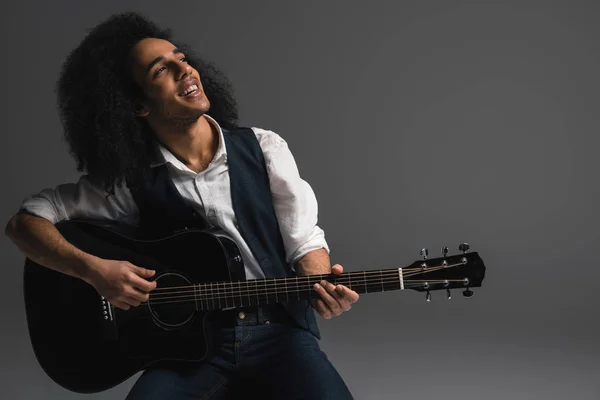 Artistic young musician playing acoustic guitar — Stock Photo