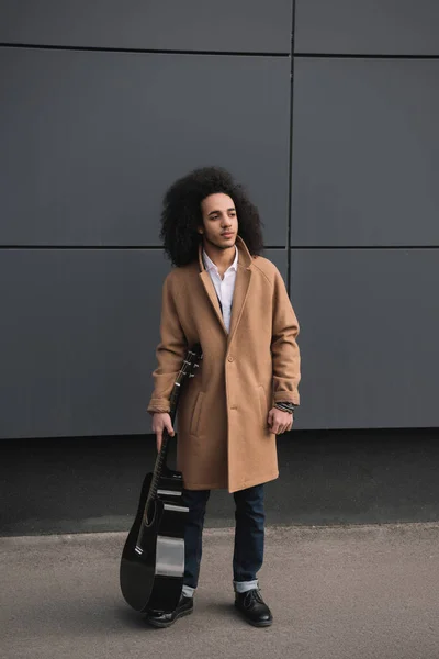 Stylish street musician standing with guitar outdoors — Stock Photo