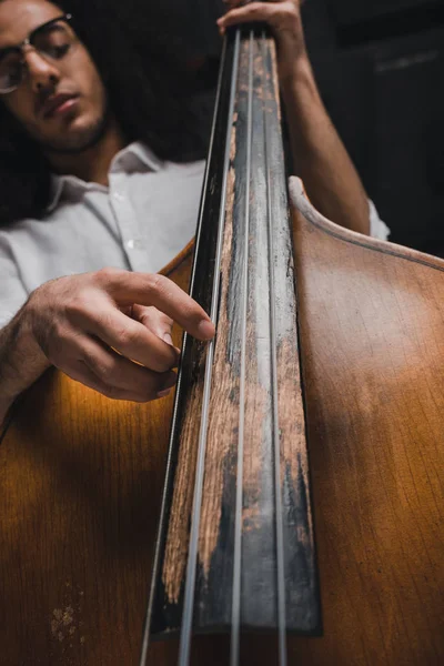 Visão inferior do músico bonito jovem tocando baixo stand-dup — Fotografia de Stock