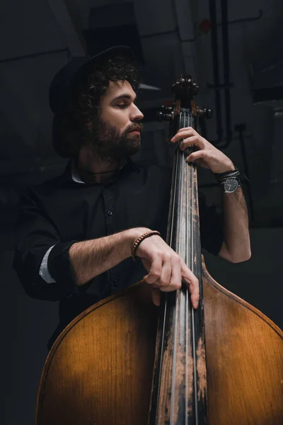 Bottom view of handsome musician playing contrabass — Stock Photo
