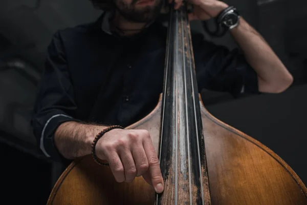 Recortado disparo de hombre tocando el contrabajo en negro - foto de stock