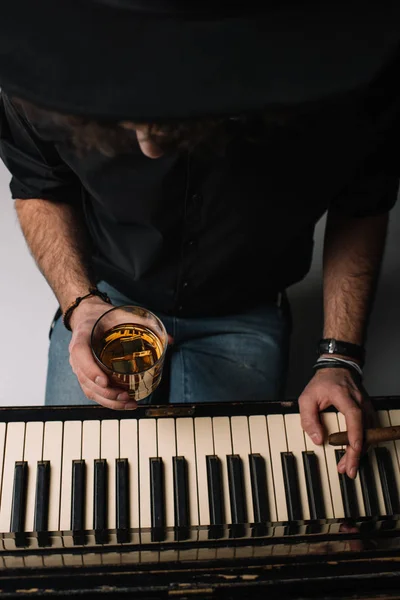 Vue grand angle du musicien avec verre de whisky et cigare jouant du piano — Photo de stock