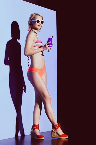 Красивая стильная девушка позирует в купальнике с коктейлем для модной съемки — стоковое фото