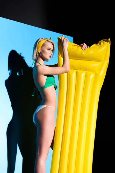 Menina elegante posando com colchão inflável amarelo — Fotografia de Stock