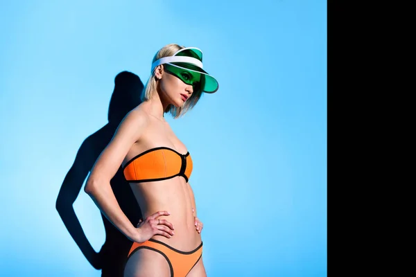 Attractive slim model posing in bikini on blue — Stock Photo