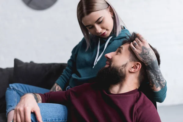 Happy tattooed girlfriend hugging boyfriend at home — Stock Photo