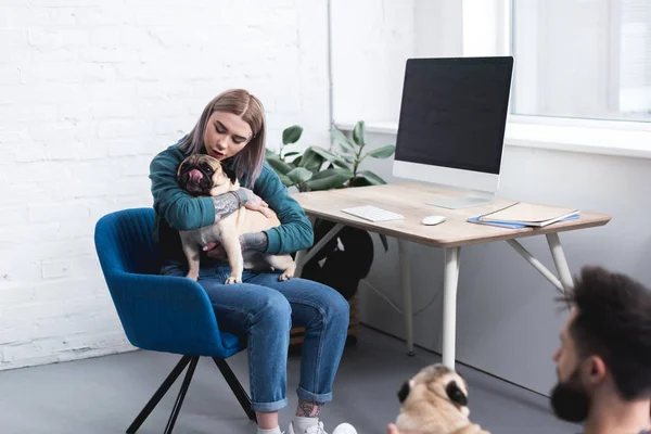 Tätowiertes Paar mit zwei Mops-Hunden zu Hause — Stockfoto