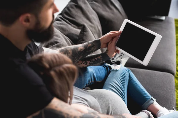Беременная девушка смотрит на планшет с парнем дома — Stock Photo