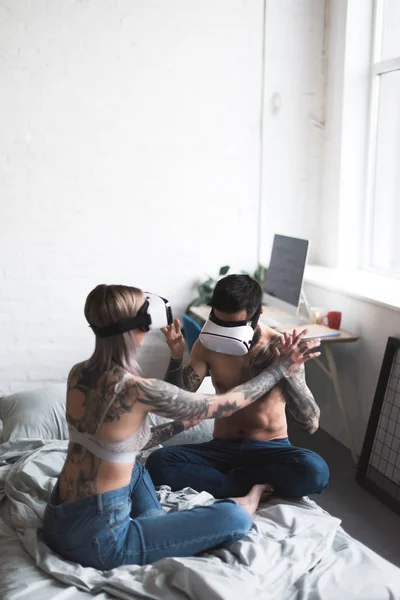 Pareja tatuada usando auriculares vr en casa - foto de stock