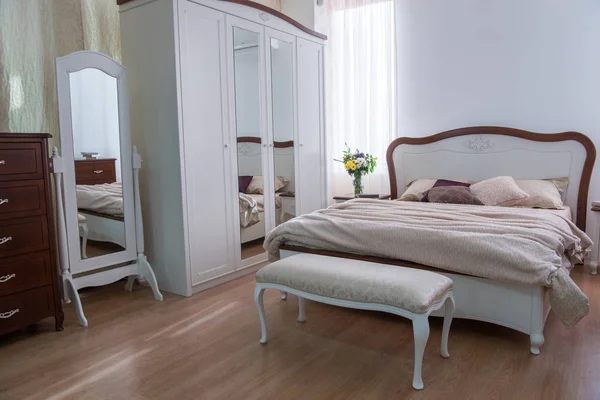 Интерьер уютной спальни с шкафом, кроватью и зеркалами в современном дизайне — стоковое фото