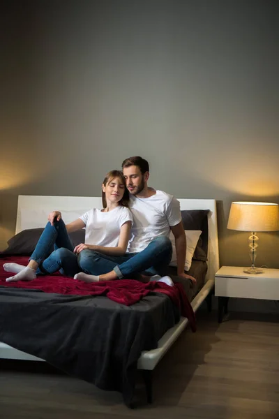 Coppia seduta ad occhi chiusi in camera da letto con interni moderni — Foto stock