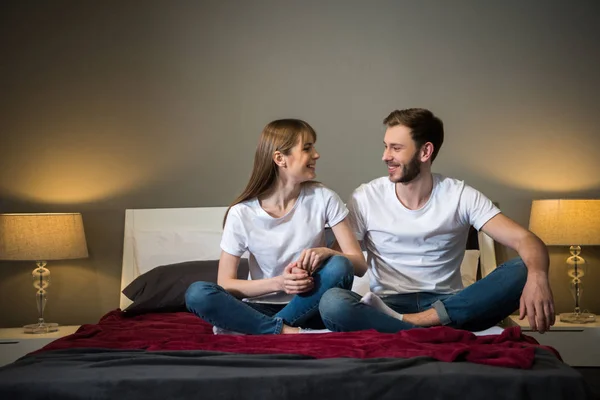 Happy young couple holding hands of each other in bedroom with modern design — Stock Photo