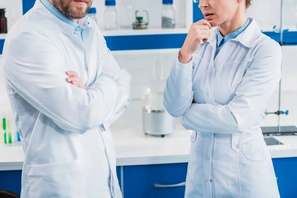 Cropped shot on scientists in white coats with arms crossed in lab — Stock Photo