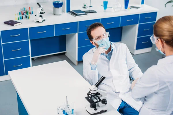 Visión parcial de los científicos debatiendo en el lugar de trabajo en el laboratorio - foto de stock