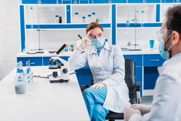 Teilweise Sichtweise von Wissenschaftlern, die am Arbeitsplatz im Labor diskutieren — Stockfoto