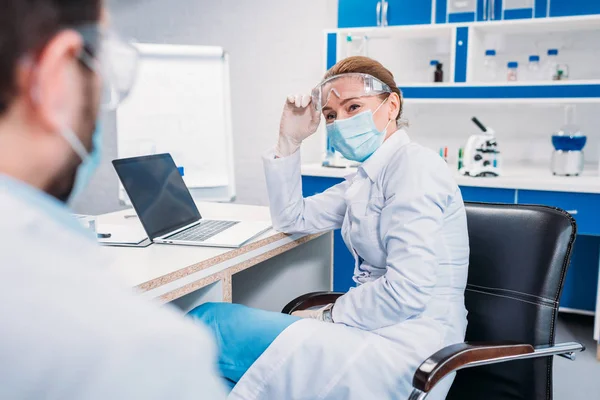 Partial view of scientific researchers in white coats at workplace in laboratory — Stock Photo