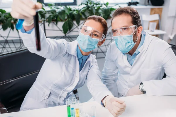 Selective focus of scientists looking at reagent in laboratory — Stock Photo
