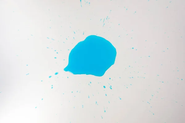 Vue rapprochée d'une tache bleue de réactif isolée sur une table blanche — Photo de stock