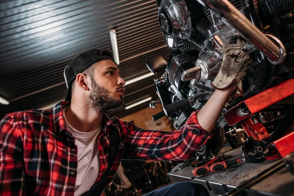 Красива станція ремонту велосипедів працівник фіксує мотоцикл — стокове фото