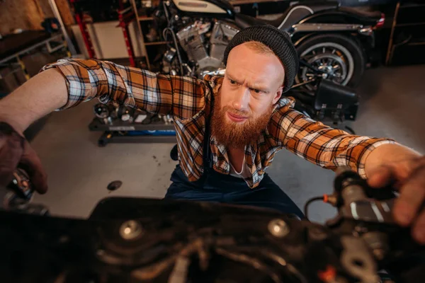 Nahaufnahme des Fahrradreparaturarbeiters, der Motorrad in Garage repariert — Stockfoto