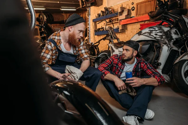 Mecânica bonito ter ruptura no trabalho na garagem e conversando — Fotografia de Stock