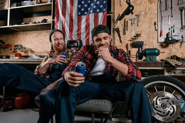 Young mechanics having lunch together at garage — Stock Photo