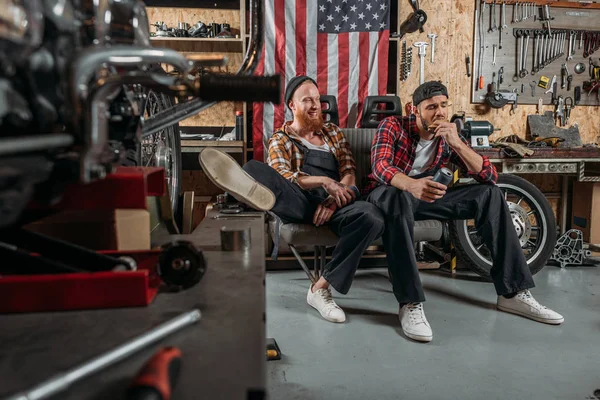 Mecânica relaxada almoçando juntos na garagem — Fotografia de Stock