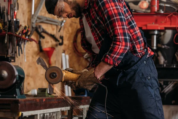 Jovem trabalhador da estação de reparação usando serra circular elétrica na garagem — Stock Photo