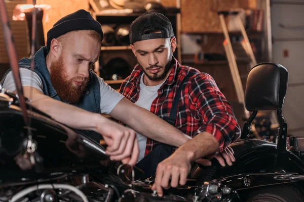 Schöner junger Reparaturarbeiter im Gespräch mit dem Kunden in der Werkstatt — Stockfoto