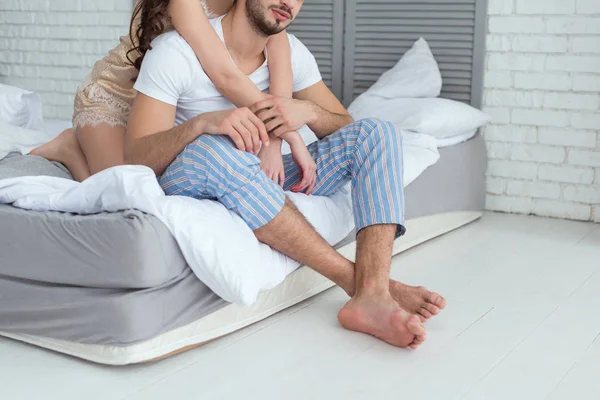 Vue partielle du couple en pyjama sur le lit à la maison — Photo de stock
