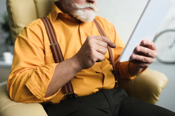 Colpo ritagliato di uomo anziano barbuto utilizzando tablet digitale a casa — Foto stock