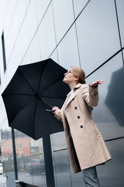 Donna d'affari in elegante cappotto con ombrello sulla strada — Foto stock