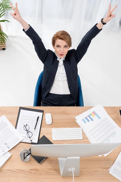 Blick von oben auf Geschäftsfrau zeigt Friedenszeichen am Arbeitsplatz im Büro — Stockfoto