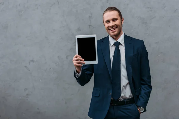 Junger lächelnder Geschäftsmann zeigt digitales Tablet vor der Kamera — Stockfoto