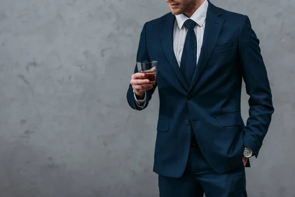 Обрезанный снимок красивого бизнесмена со стаканом виски — стоковое фото