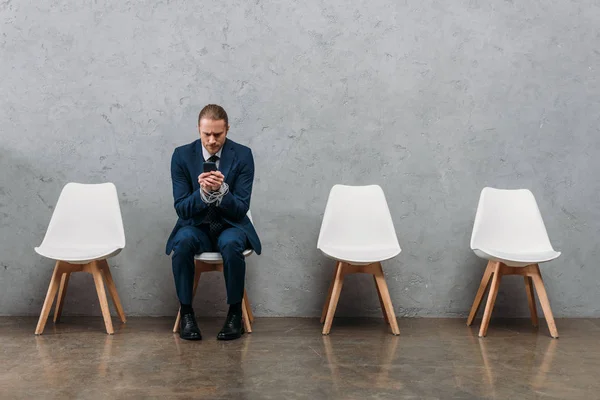 Lonely businessman sitting on chair and using phone, phone addiction concept — Stock Photo